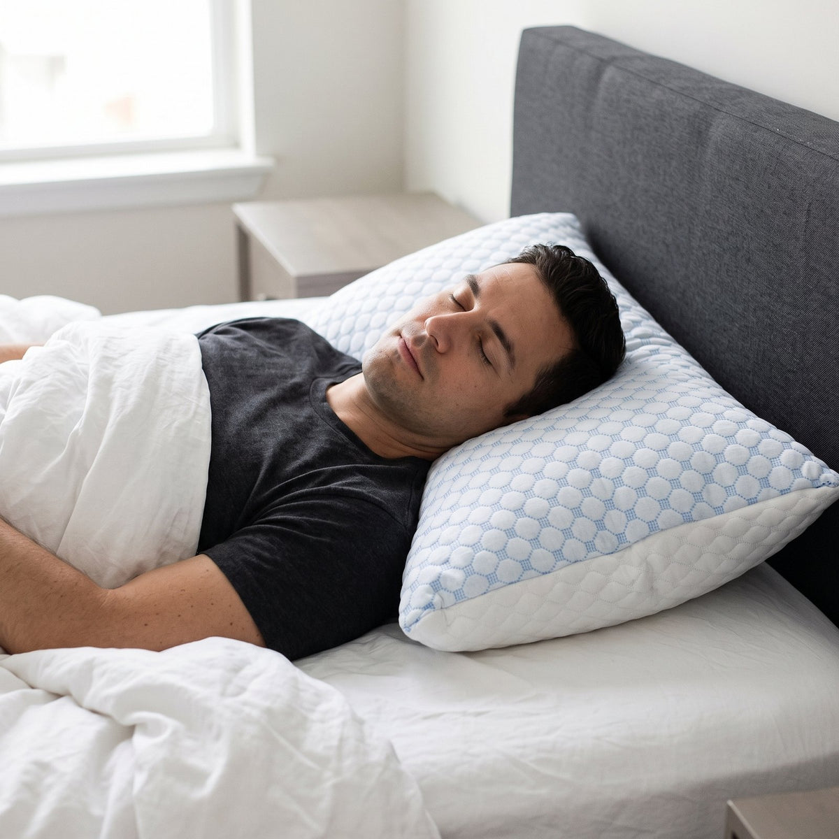 Man sleeping on his back on the white and light blue quilted ArcticLoft king pillow