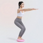 Woman doing a squat while standing on the pink wobble cushion