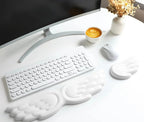 White wing-shaped keyboard and mouse wrist rests on a white desk with keyboard and mouse