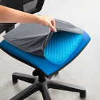 Hand lifting the gray cover to show the blue honeycomb cushion on an office chair