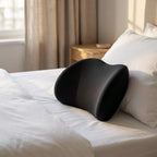 NightArc lumbar pillow resting on a bed in front of white pillows