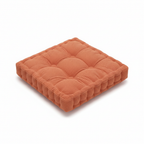 Orange tufted floor cushion seen from above at an angle