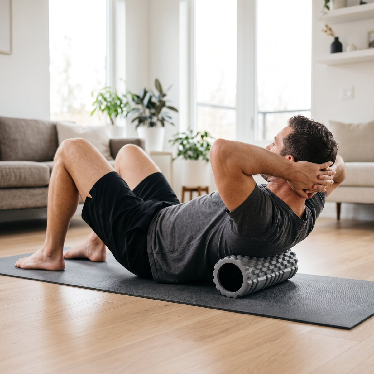 Man rolling his upper back on the gray FasciaFlow textured roller on a mat