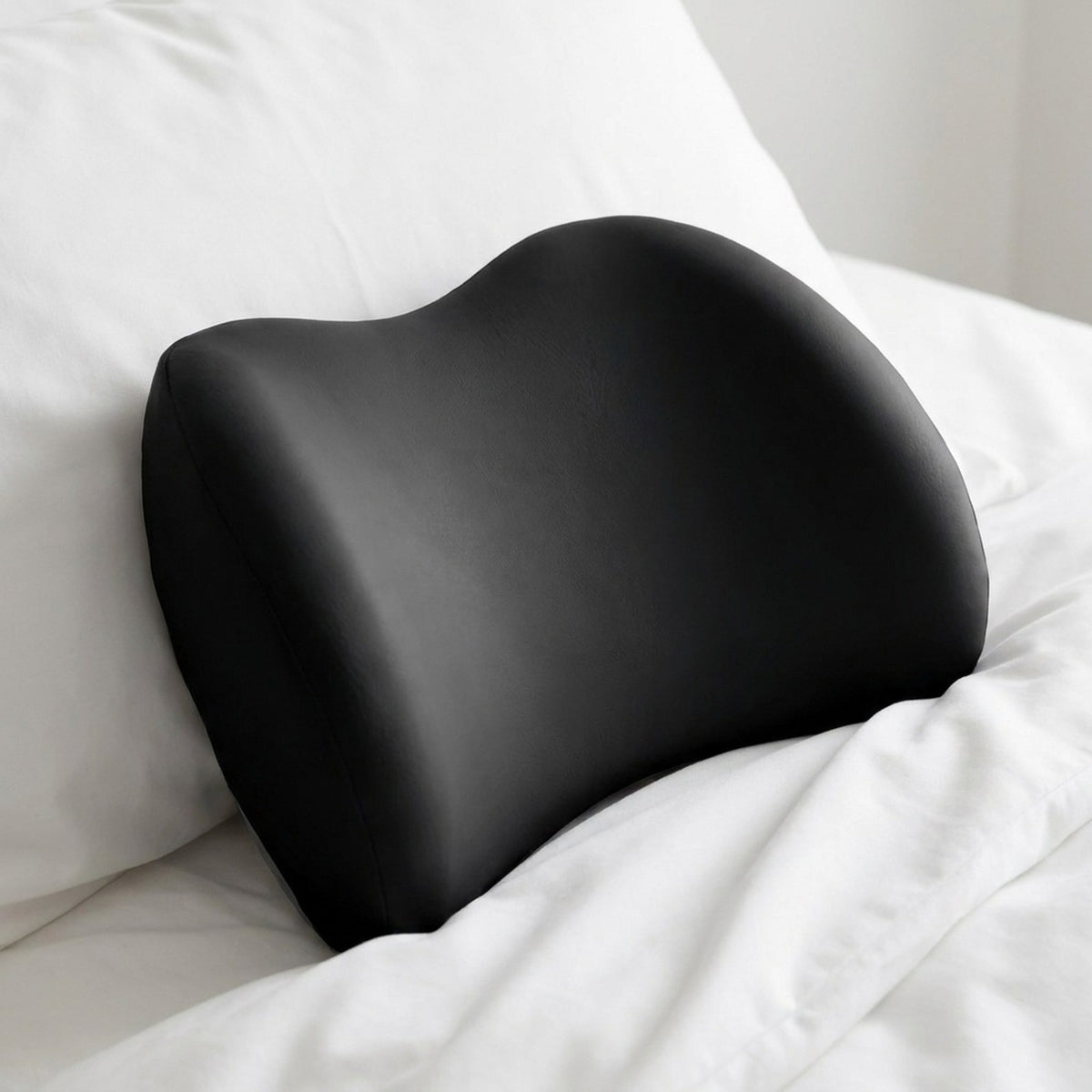 Close-up of the black NightArc lumbar pillow showing the center dip and raised sides