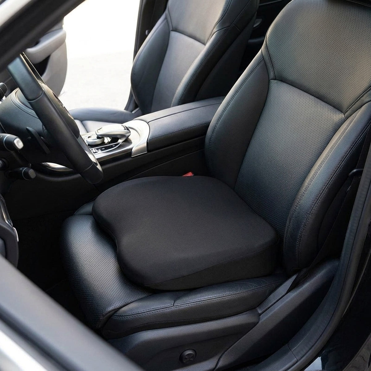 Black RideRise seat booster cushion on the black leather driver's seat of a car