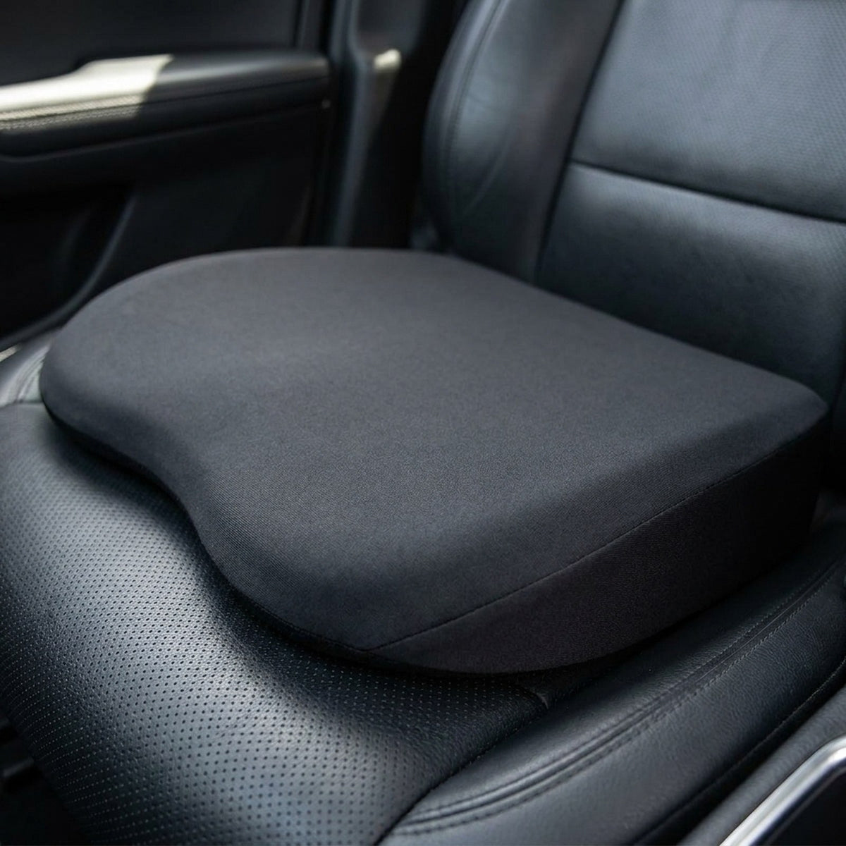 Close-up of the RideRise cover and its sloped profile on a leather car seat