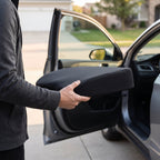 Black RideRise cushion carried in one hand next to an open car door