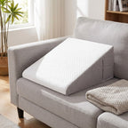 SleepWell bed wedge pillow with white top and gray sides on a light gray sofa