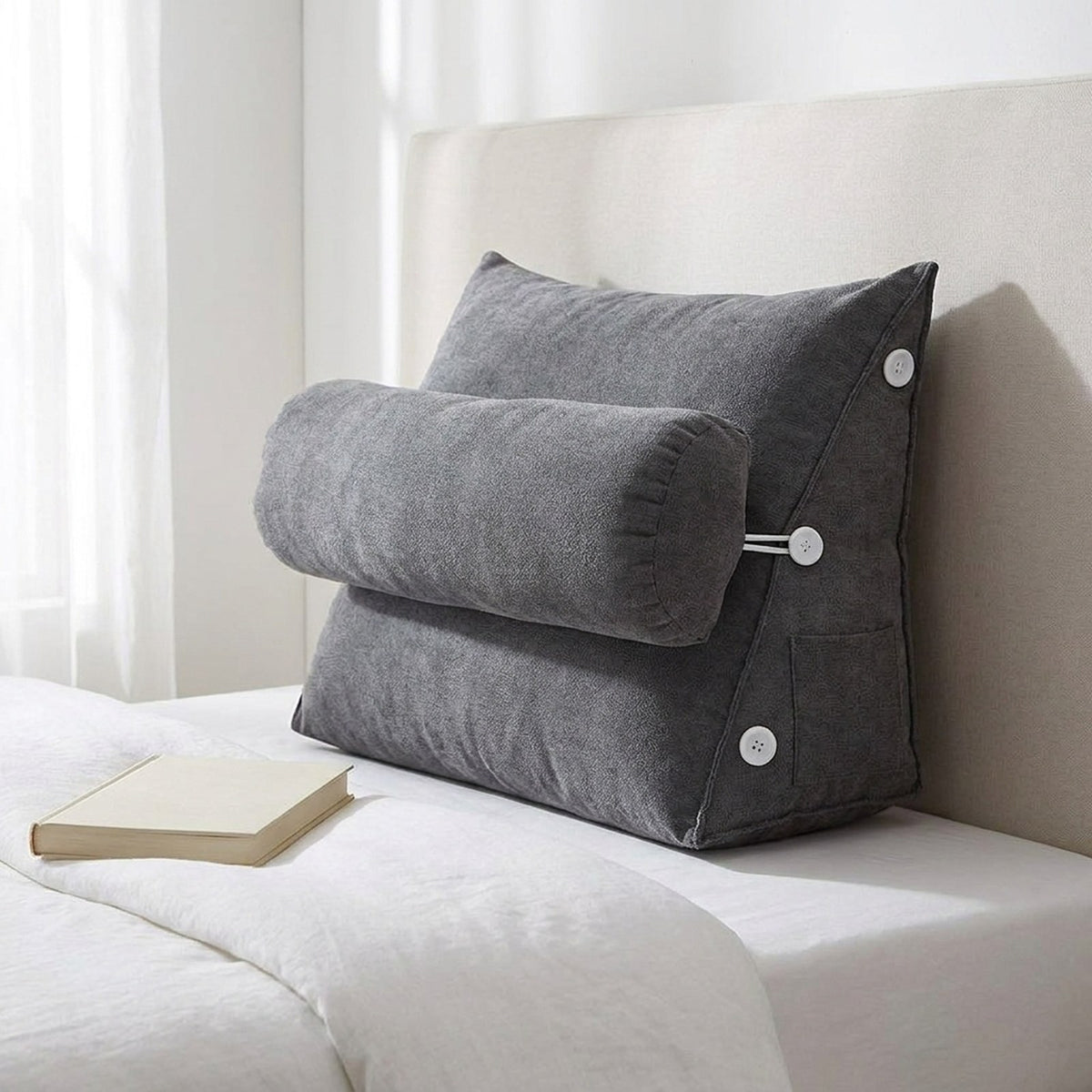 Charcoal gray WedgeRest reading pillow against an upholstered headboard